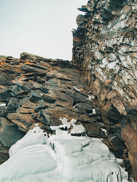 A stunning cliff that features an extensive arrangement of rocks combined with a captivating layer of snow covering its surface, creating a breathtaking winter scene