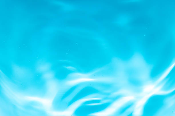 Blue macro wave texture,Closeup​ abstract​ of​ surface​ blue​ water​ for​ background. Reflection​ on surface​ swimming​ pool​ for​ background. Water​ splash​ for​ graphic​ design.