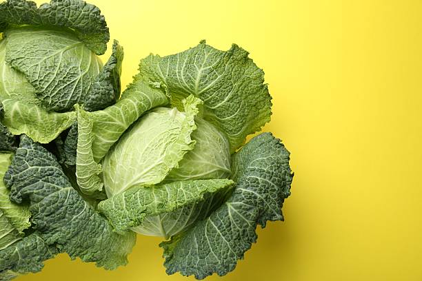 istock Fresh Savoy cabbages on yellow background, flat lay. Space for text 2249756945