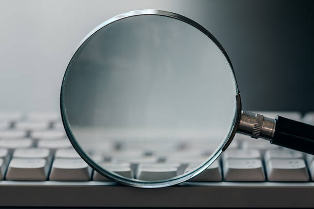 istock A magnifying glass rests on a computer keyboard, symbolizing search, detail, investigation, and digital security. 2249758408