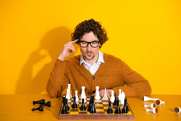 istock Young mature man with glasses in a yellow studio plays chess and reflects on work and life while promoting style and shopping 2249758749