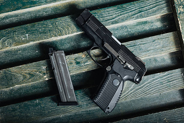 istock military firearm setup, service pistol on ammunition box, olive drab pistol resting against wooden 2249760342