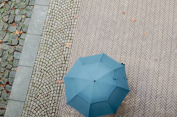 istock Top view of a blue umbrella on a footpath 2249762715