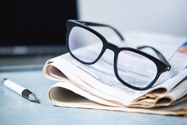istock A pile of newspapers ,glasses and computer on the table. 2249768139