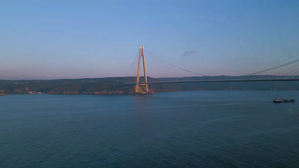 istock Sunset in Istanbul: Cargo Ship Passing under Yavuz Sultan Selim Bridge at Sunrise 2249776825
