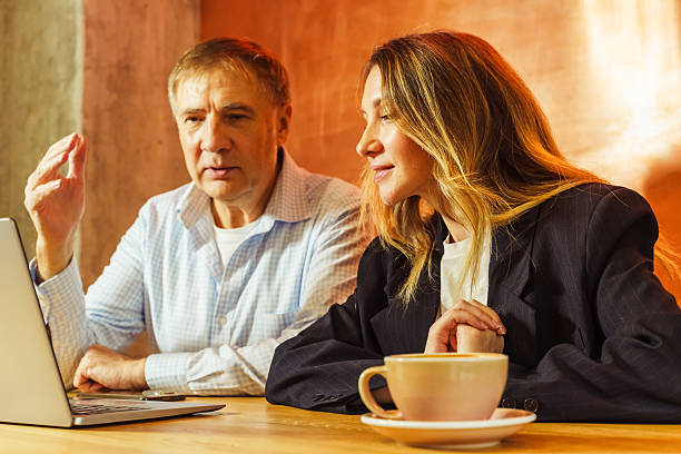 Two colleagues share thoughtful ideas over lunch at a cafe, engaged in an animated discussion about work.