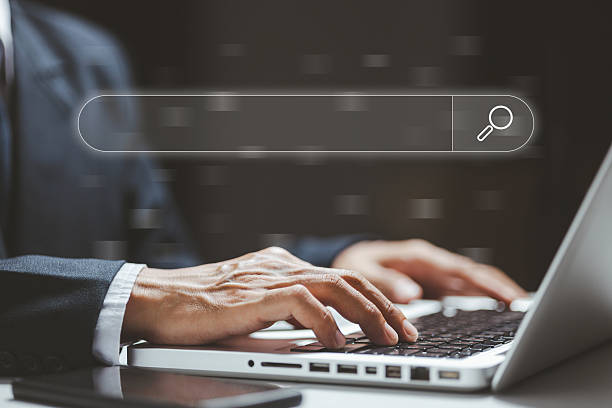 istock Hands typing on a laptop with a transparent search bar interface, representing SEO optimization, online searching, digital workflow, and modern technology used for research and data management. 2249780071