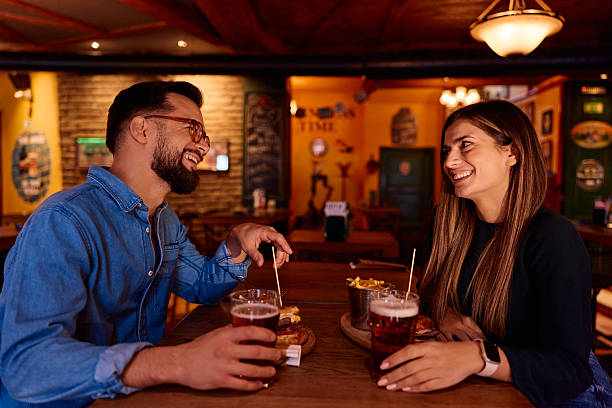 istock Couple enjoying beer and snacks while laughing at bar 2249784554