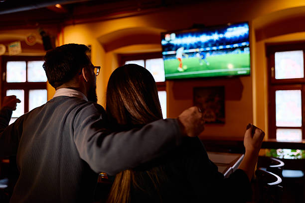 istock Couple watching soccer game in bar celebrating win 2249785338