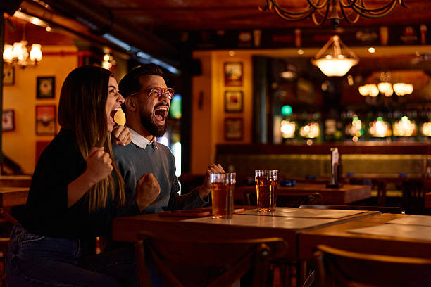 istock Excited couple cheering while watching sports in a bar 2249785590