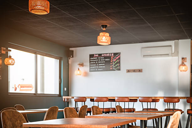 istock Empty interior of a modern microbrewery and restaurant featuring wooden tables and leather chairs bathed in warm sunlight 2249785765