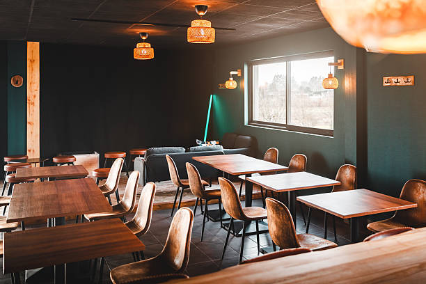 istock Empty wooden dining tables and brown chairs arranged in a sunlit microbrewery taproom 2249785775