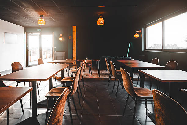 istock Empty wooden dining tables and brown chairs arranged in a sunlit microbrewery taproom 2249785777