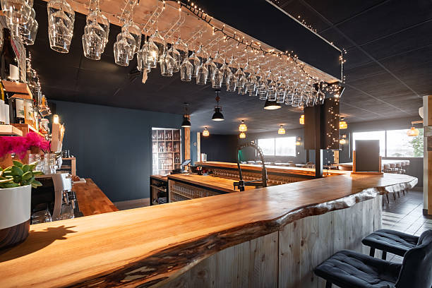 istock Wooden bar counter and hanging glasses illuminated by warm string lights inside a modern microbrewery in France 2249785818