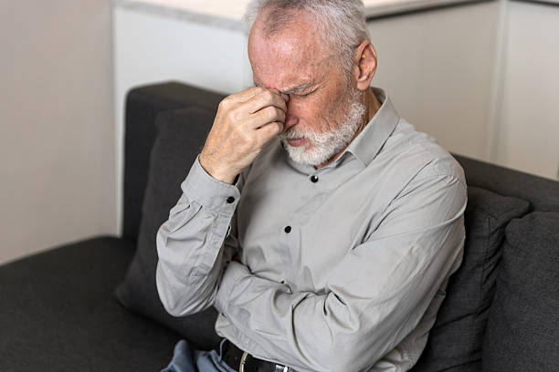 istock Man experiencing headache while sitting in living room at home 2249785911