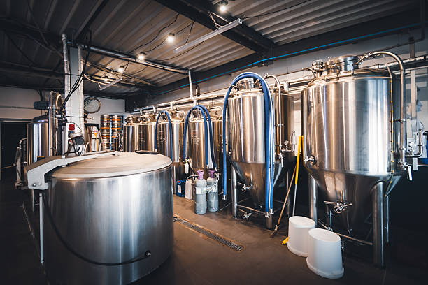 istock Stainless steel fermentation tanks standing in a row inside French craft microbrewery production area 2249785941