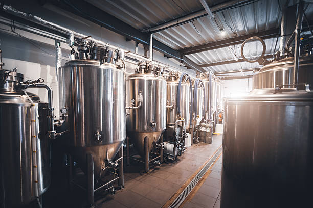 istock Stainless steel fermentation tanks aligned in sunny craft microbrewery production hall in France 2249785955