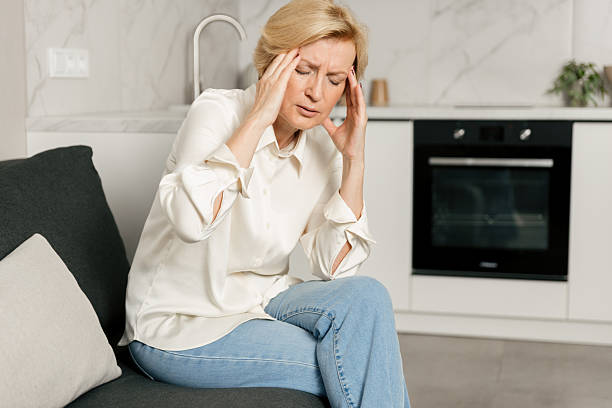 istock Woman experiencing severe headache at home while sitting on the couch 2249786382