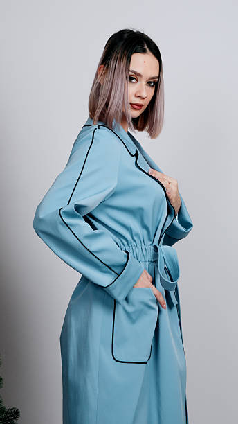 istock Woman in a light blue silk robe holds it closed at her chest 2249790525
