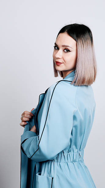 istock A woman in a light blue shirt is standing and looking back over her shoulder 2249790643