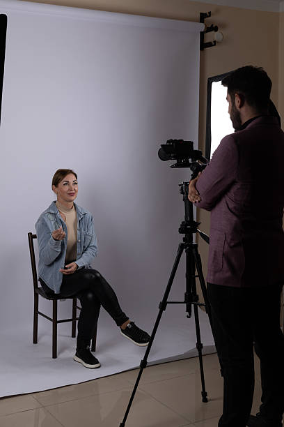 istock Professional photo shoot setup with model sitting and two photographers working 2249796146