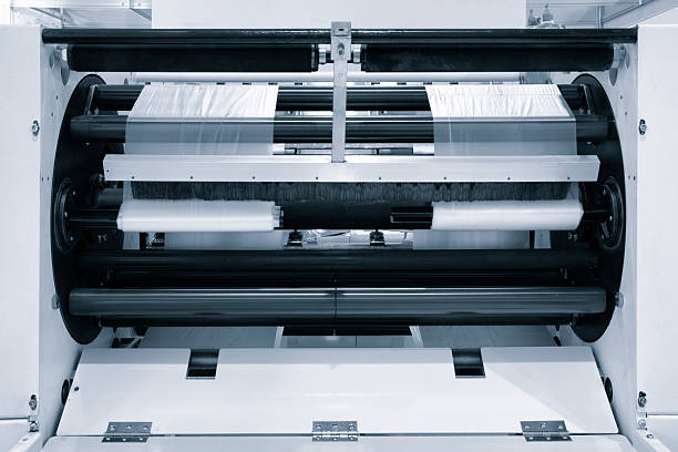 istock Automatic polyethylene plastic bag production machint. Close-up of the roller of plastic bag production machine in the light blue scene. product packaging concept 2249796406