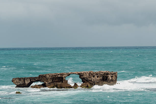 Perforated rock formation in the blue sea