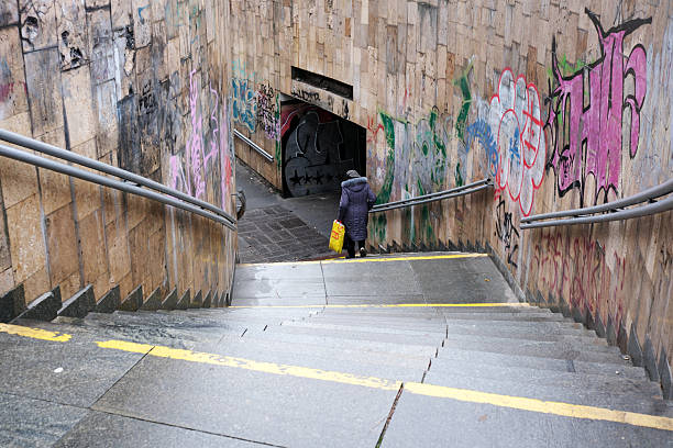 A person walks down a wet stairway decorated with vibrant graffiti. Kyiv, Ukraine, November 26, 2025.