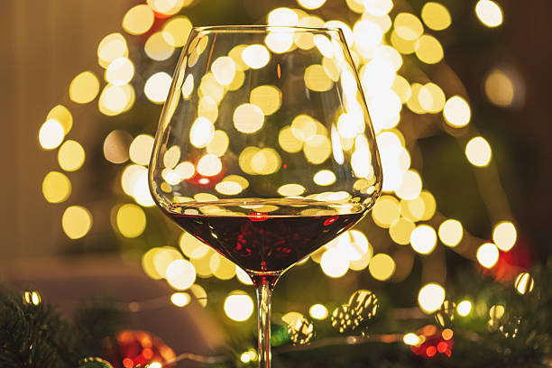 istock Christmas Table Setting with Wineglasses with Red Wine against Christmas lights 2249804169