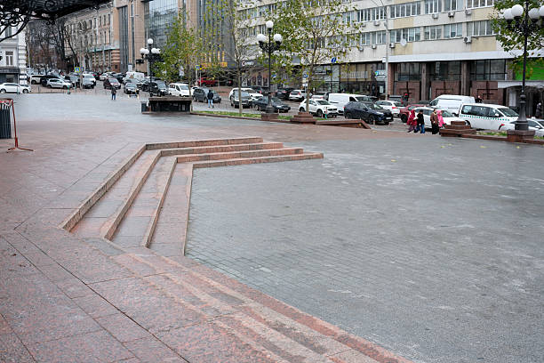Stairs create an artistic flow in a busy street under a cloudy sky. Kyiv, Ukraine, November 26, 2025.