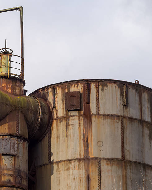 istock Rusty industrial tanks and pipes reaching for the cloudy sky 2249805242