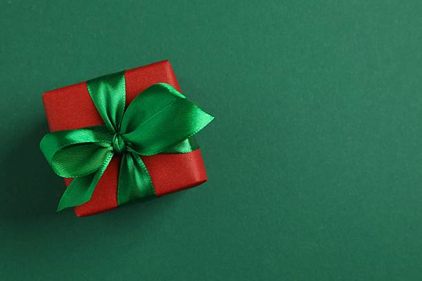 istock Beautiful gift box tied with bow on green background 2249809615