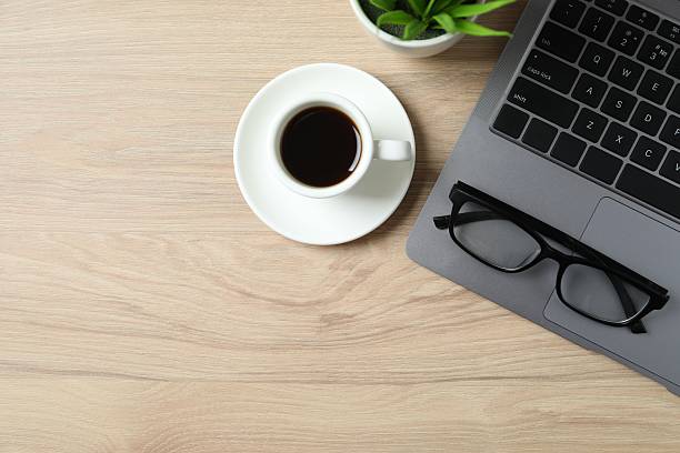 istock Workplace with laptop, glasses and coffee cup, top view 2249813109