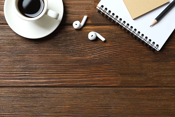 istock Office table with notebook, pencsil, coffee cup and headphones, top view 2249813345