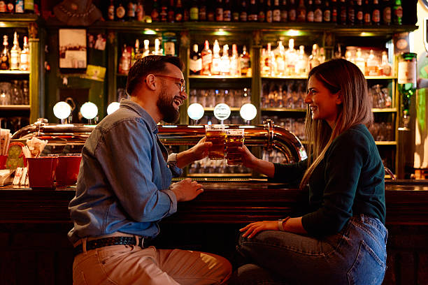 istock Couple celebrating and toasting with beer at a bar 2249814720