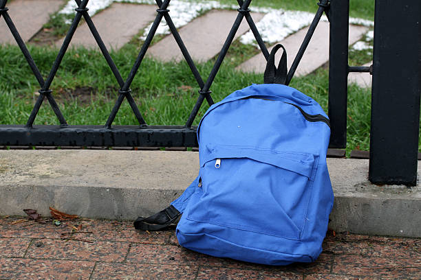 istock Blue backpack abandoned near fence on sidewalk 2249815305