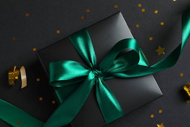 istock Black gift box with confetti on dark background 2249817169