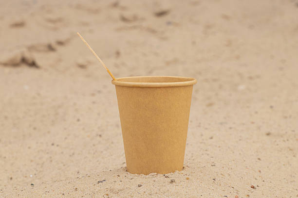 istock A disposable paper cup sits on the sand with a wooden stick inside, creating an atmosphere of relaxation, a break, and a summer moment 2249824497