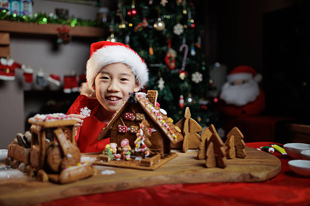 A young girl was decorating a gingerbread house to celebrate Christmas at home