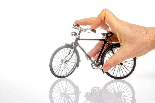 istock man hand on a bicycle model on a white background. cycling concept 2249841095