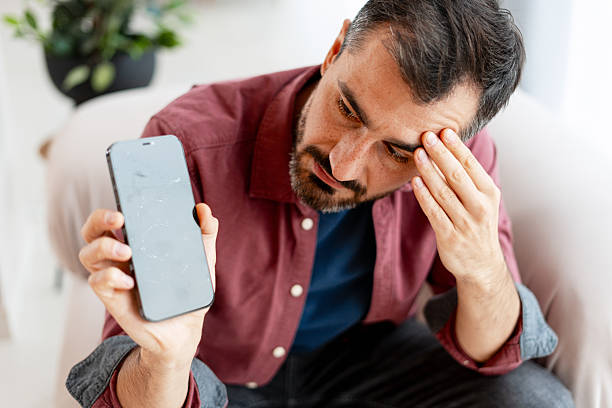 istock Sad man feeling frustrated and stressed holding broken phone 2249843563
