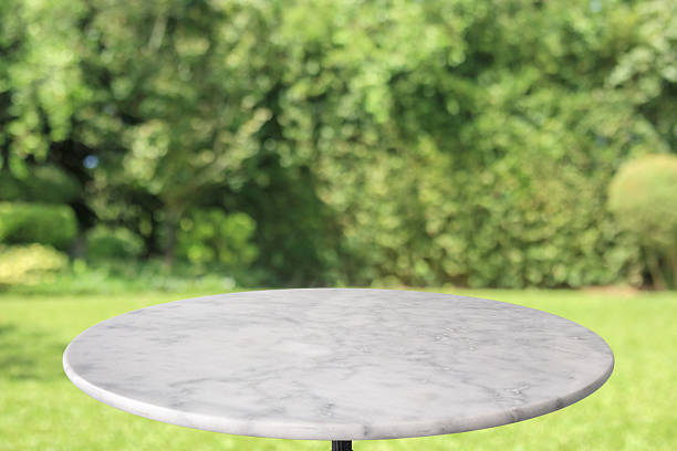istock Empty round marble table top with abstract blur green park garden background 2249848519