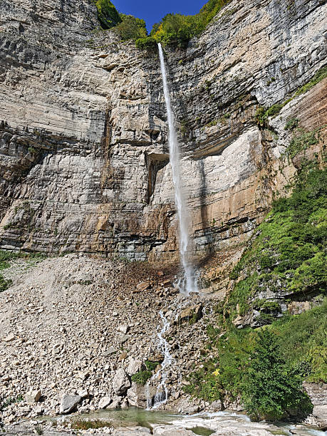 istock Kinchkha Big Waterfall dramatically drops from a sheer, multi-layered cliff face onto a rocky scree slope below, highlighting the immense scale and power of nature in Khoni Municipality, Georgia 2249852892