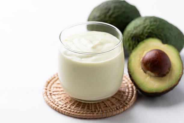Avocado smoothie with milk in glass and avocado fruit on white background