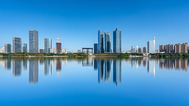 istock Modern city skyline with calm water reflection under clear blue sky 2249861998