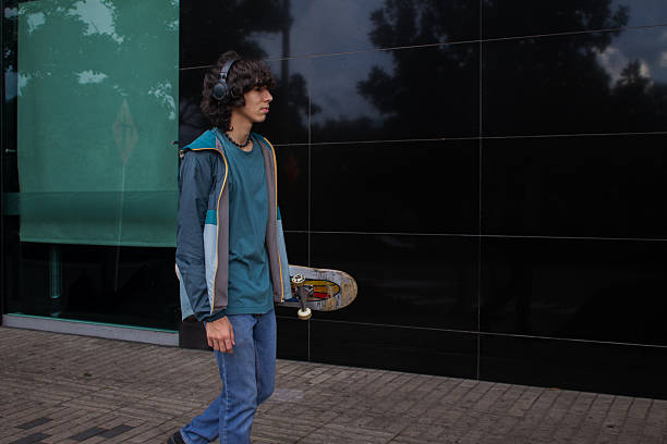 Young man walking on the holding a skateboard