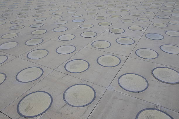 rough wet street pathway in grid pattern for design, top view. cobble granite stone, square shape in grid on the outdoor pathway. sidewalk texture made of stone tiles.