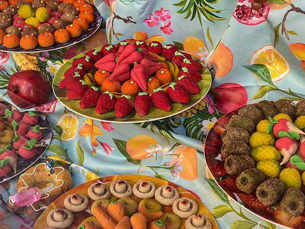 Colorful marzipan fruit with whimsical faces and expressions displayed in a market.