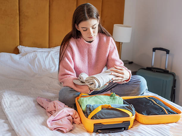 istock Woman packing suitcase on bed in hotel room 2249884092
