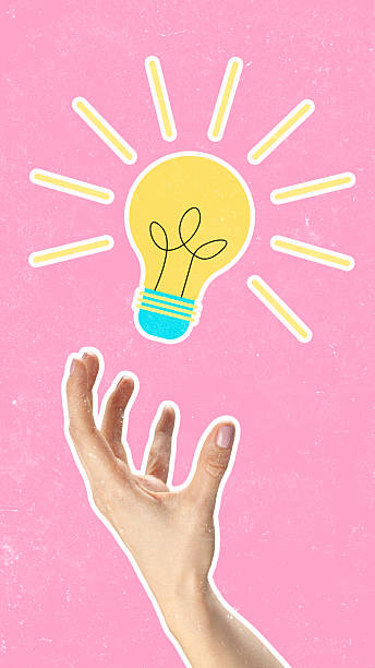 istock Bright ideas shine from a hand reaching for a light bulb on a pink background 2249884162